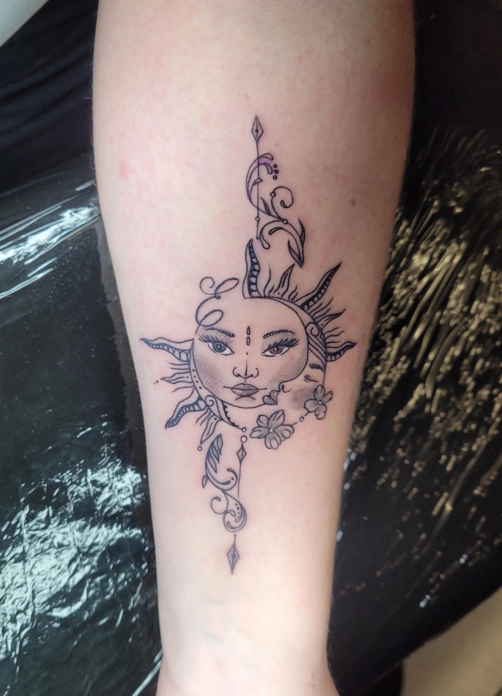 Tatouage fine line soleil et lune sur avant-bras - JMJ Tattoo Sérignan